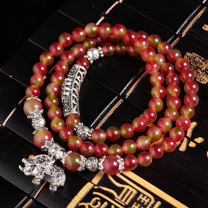 Handmade bracelet with geometric watermelon crystal beads and a Chinese knot closure.