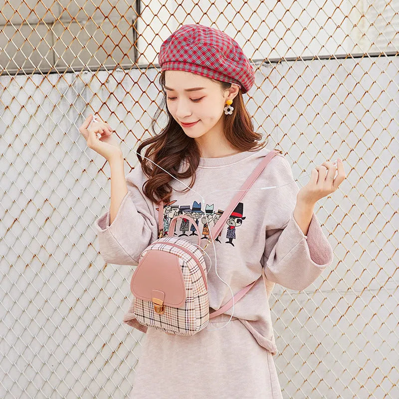 A one shoulder diagonal phone bag made from black PU fabric, shown being worn crossbody.