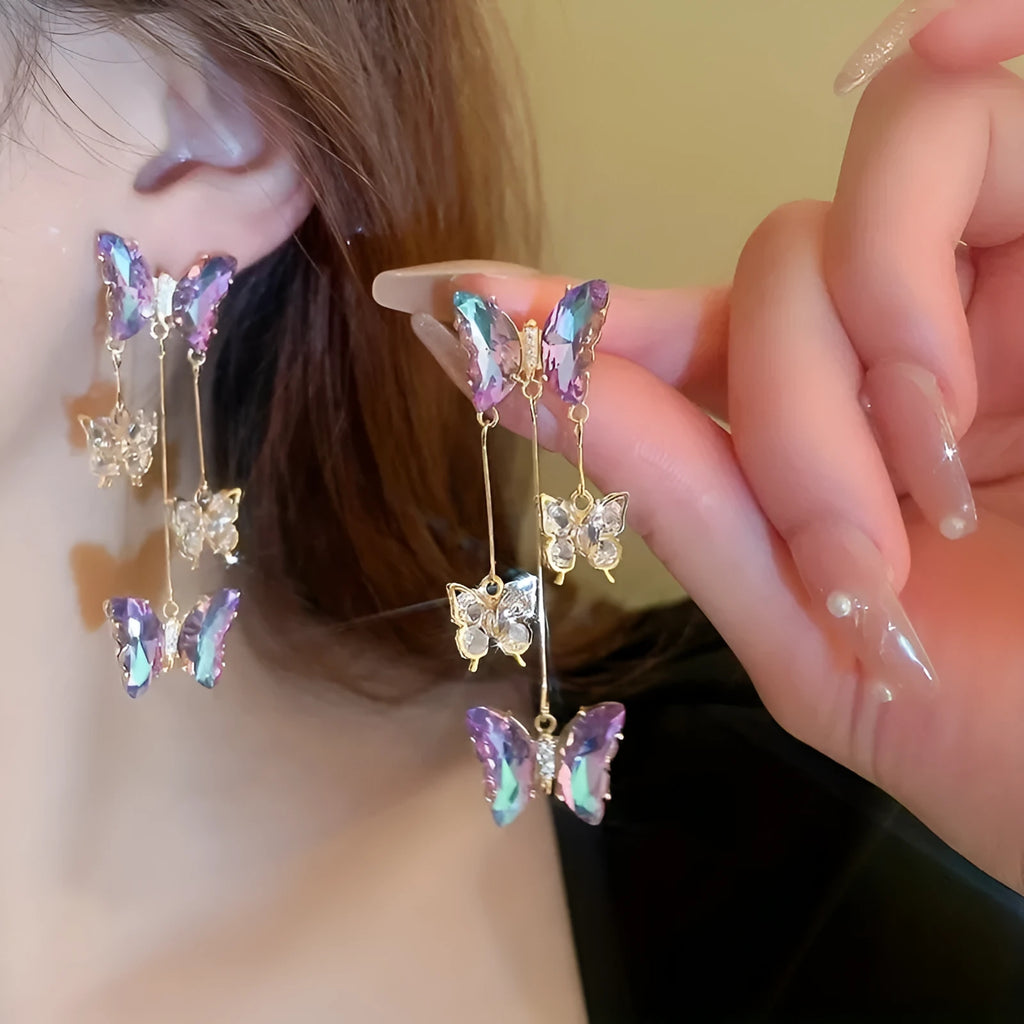Blue purple butterfly-shaped drop earrings with crystal flowers and a metal tassel.
