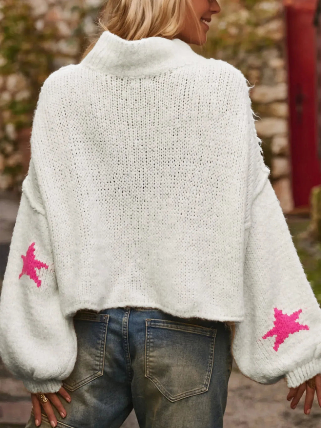 White women's loose turtleneck pullover with a black five-pointed star pattern on the front.