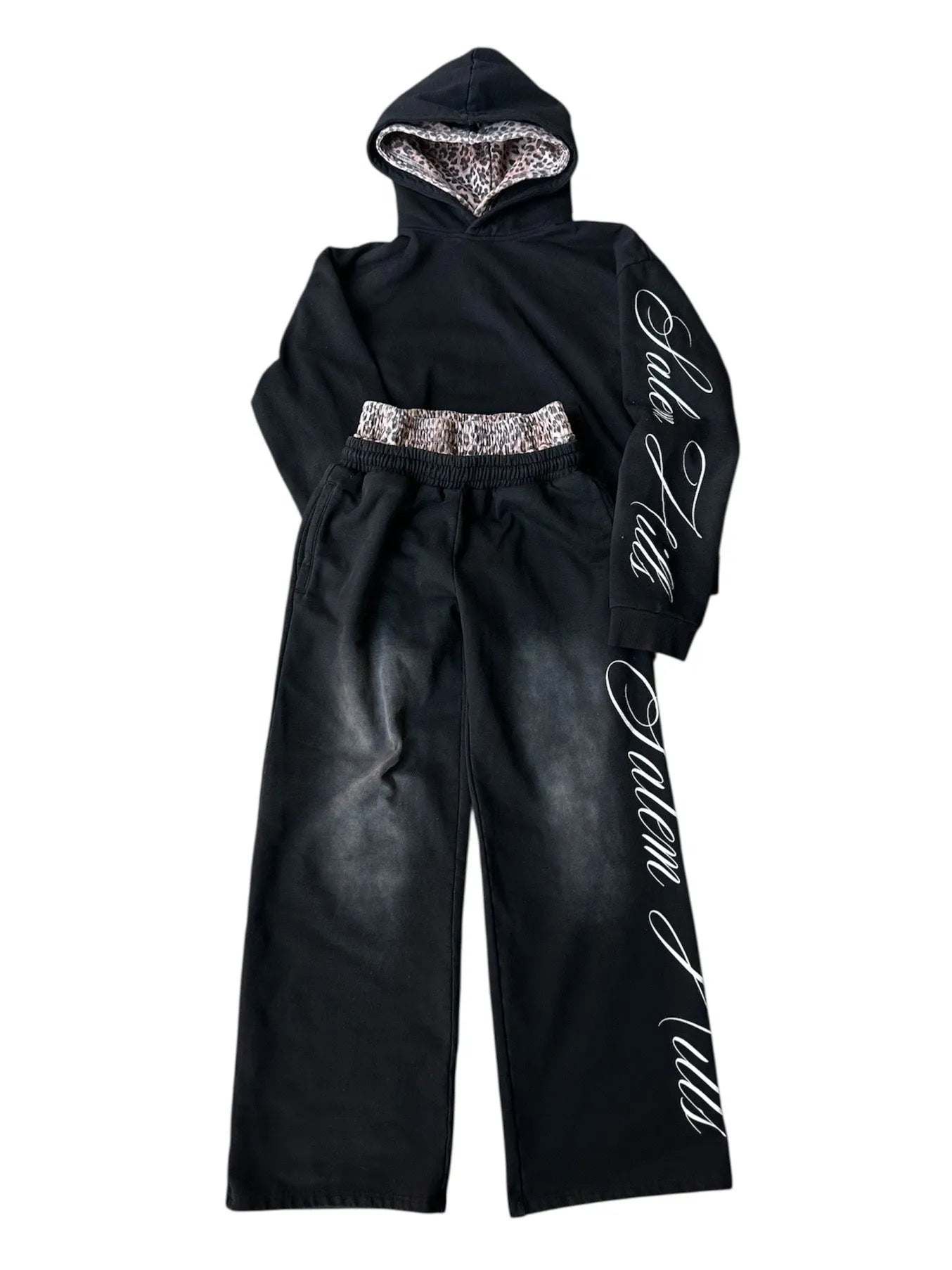 Men's black and white punk print pullover hoodie and pants tracksuit set on a hanger.