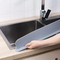 A grey silicone sink water blocking plate measuring 52mm by 85mm.