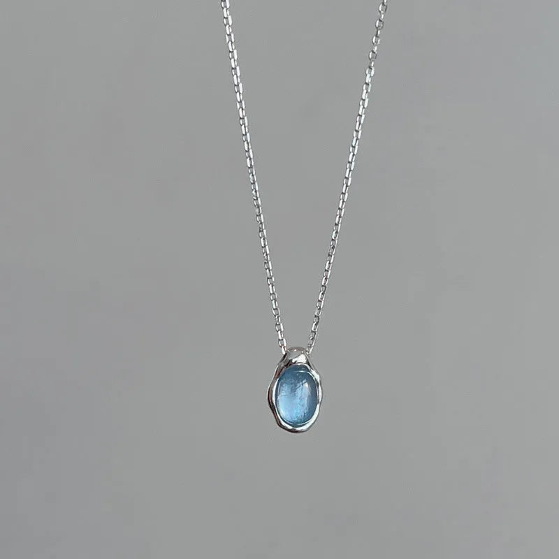 A women's navy blue geometric water drop pendant necklace with a platinum-colour finish on an adjustable cross chain.