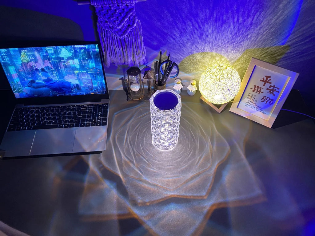 Creative acrylic crystal rose LED table lamp with adjustable three-colour lighting on a wooden surface.
