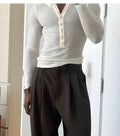Cream-coloured men's ribbed long-sleeve Henley top with a buttoned placket.