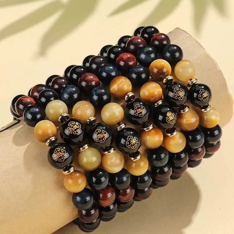 Handmade black agate beaded bracelet with gold, blue, and red tiger eye stones featuring Buddhist deity and zodiac animal motifs.