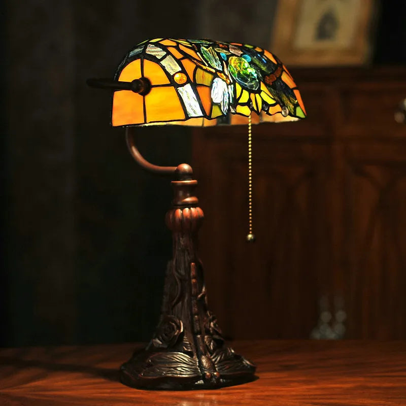 10-inch Tiffany stained glass table lamp on a desk with a warm glow.