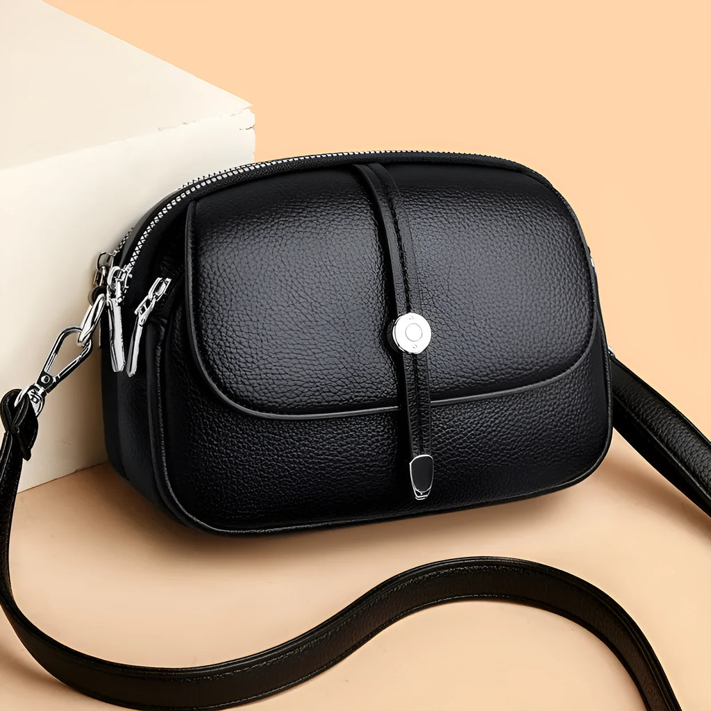 Women's soft PU leather crossbody shoulder bag in oval suitcase shape, shown in black colour with decorative sewing thread detailing.