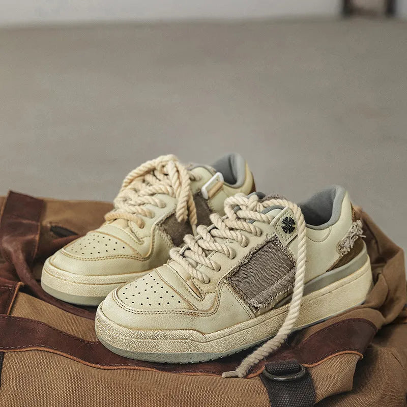 Beige low-top skateboard shoes with microfiber upper and flat rubber sole on white background