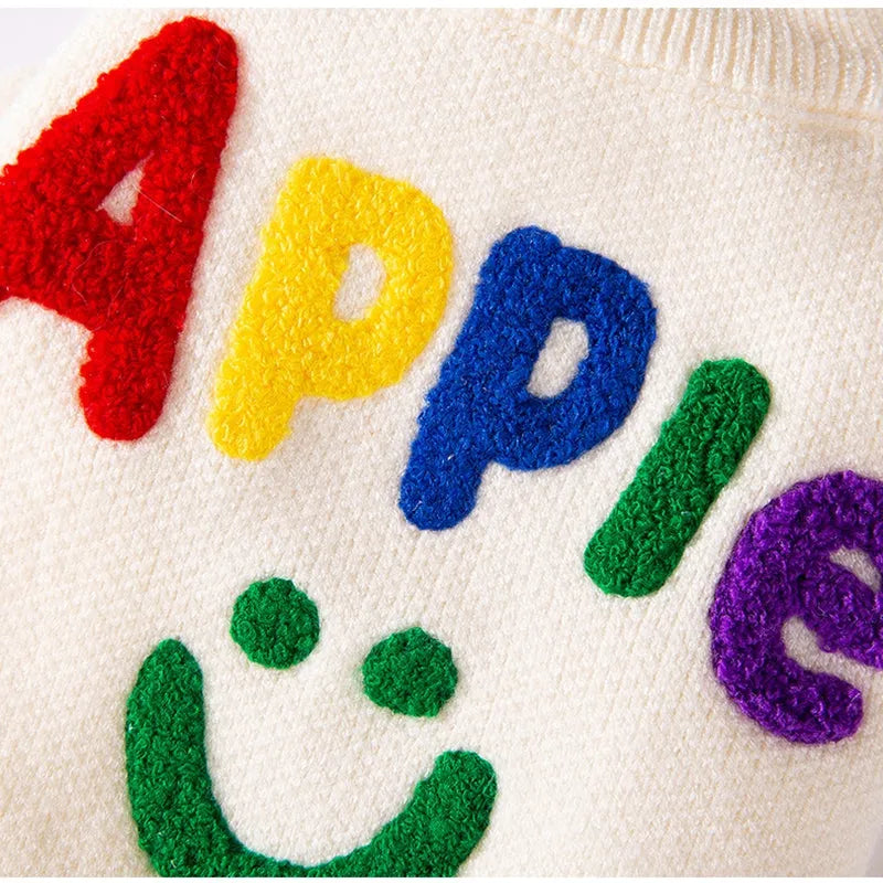 White knitted small dog sweater with rainbow Apple embroidery and green smiley face on a pet