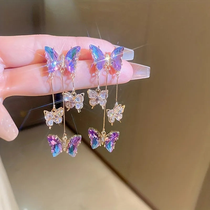 Blue purple butterfly-shaped drop earrings with crystal flowers and a metal tassel.