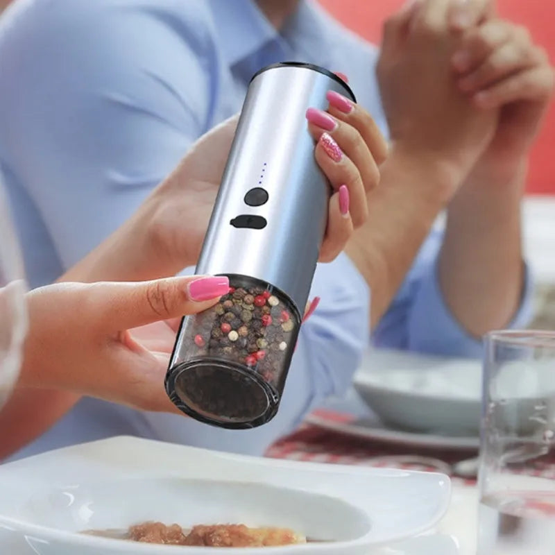 White electric pepper and salt grinder with stainless steel top and clear glass jar showing LED lights