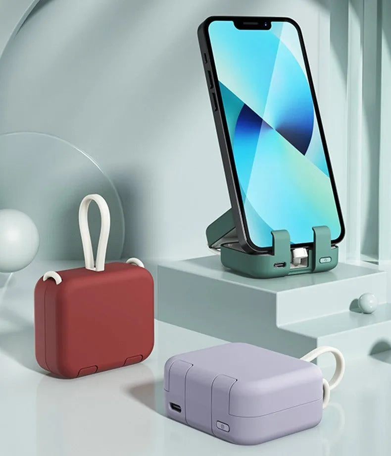 Red portable power bank with an extended bracket holding a mobile phone.