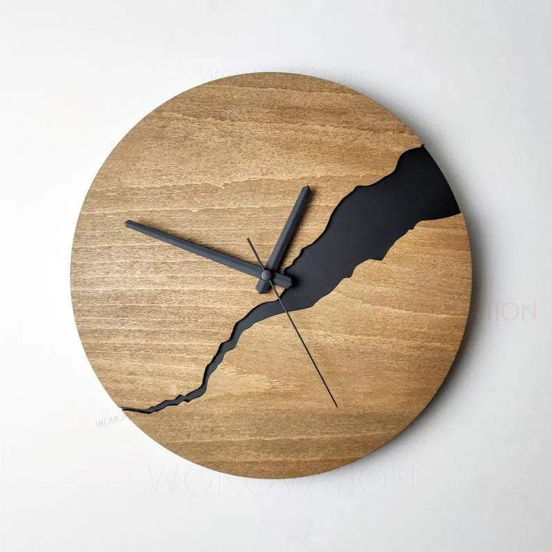 Modern wooden wall clock with a cracked surface design on a plain wall.