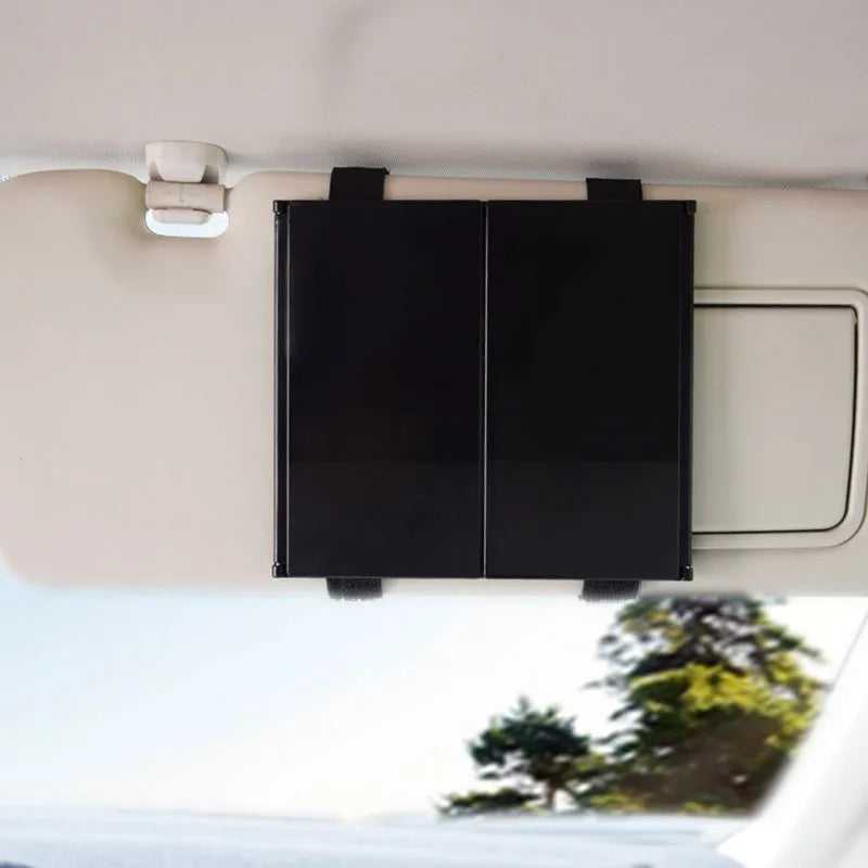 Silver portable car folding mirror shown both closed and opened on a flat surface.