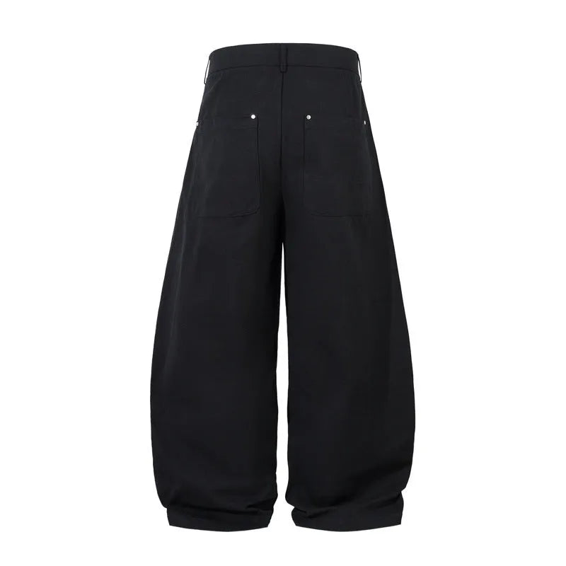 Man wearing black pleated wide-leg casual cotton trousers in a loose fit.