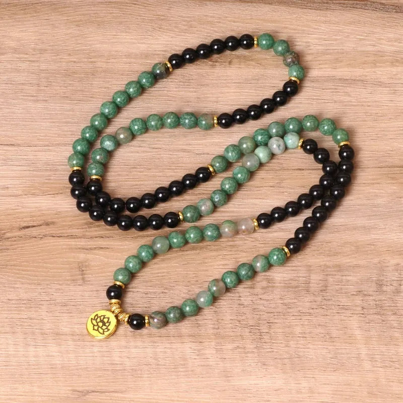 Long elastic bracelet with green and black alloy charms and natural style beads on a stretch band.