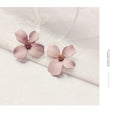 Women's floral stud earrings in white or pink electroplated alloy with flower shape design