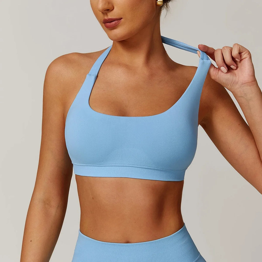 Women's black halter-style yoga sports bra with medium support and built-in chest pads.