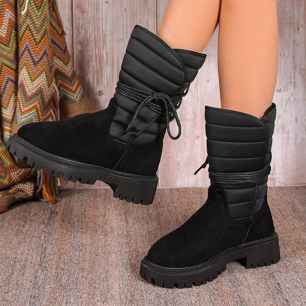 Women's black suede snow boots with chunky heel, fleece lining, and lace-up design.