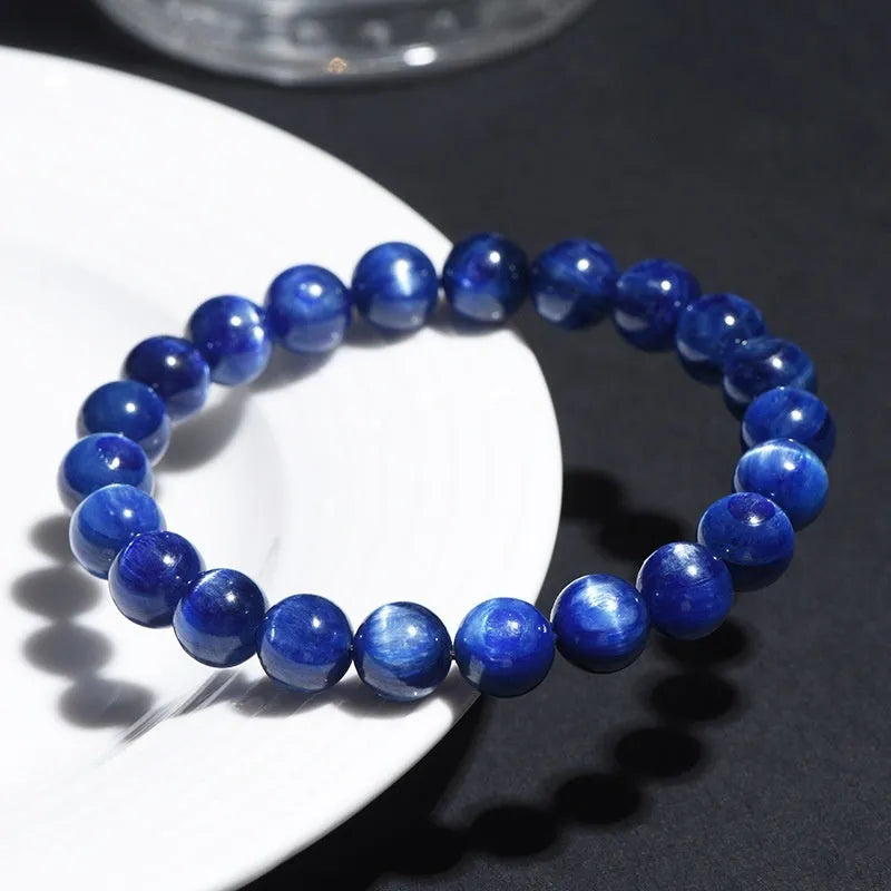 Blue crystal ball bracelet with geometric design and Ruyi motif on a white background.