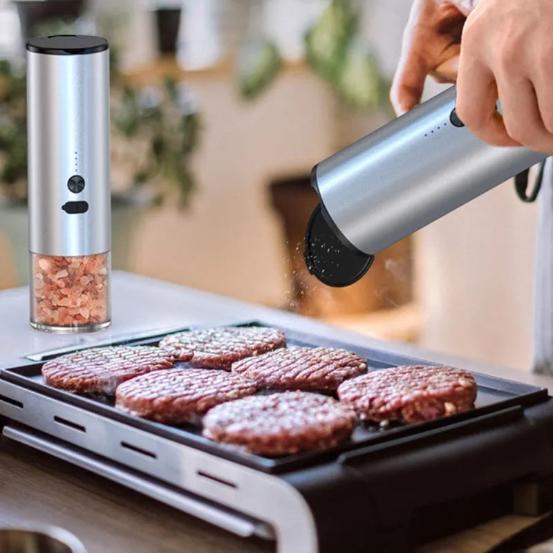 White electric pepper and salt grinder with stainless steel top and clear glass jar showing LED lights