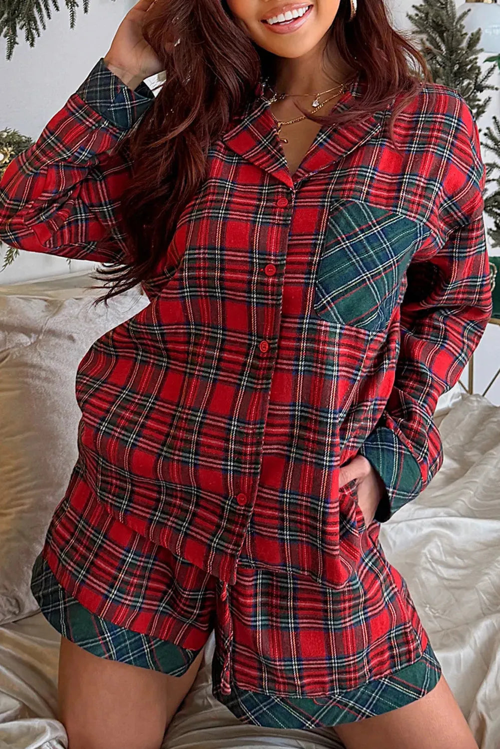 Red plaid long sleeve pyjama shirt and matching shorts set on a white background.
