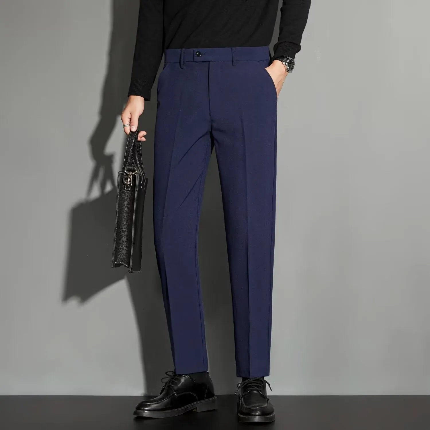 Men's straight-leg ankle-length suit trousers in a light colour showing spring draping effect detail.