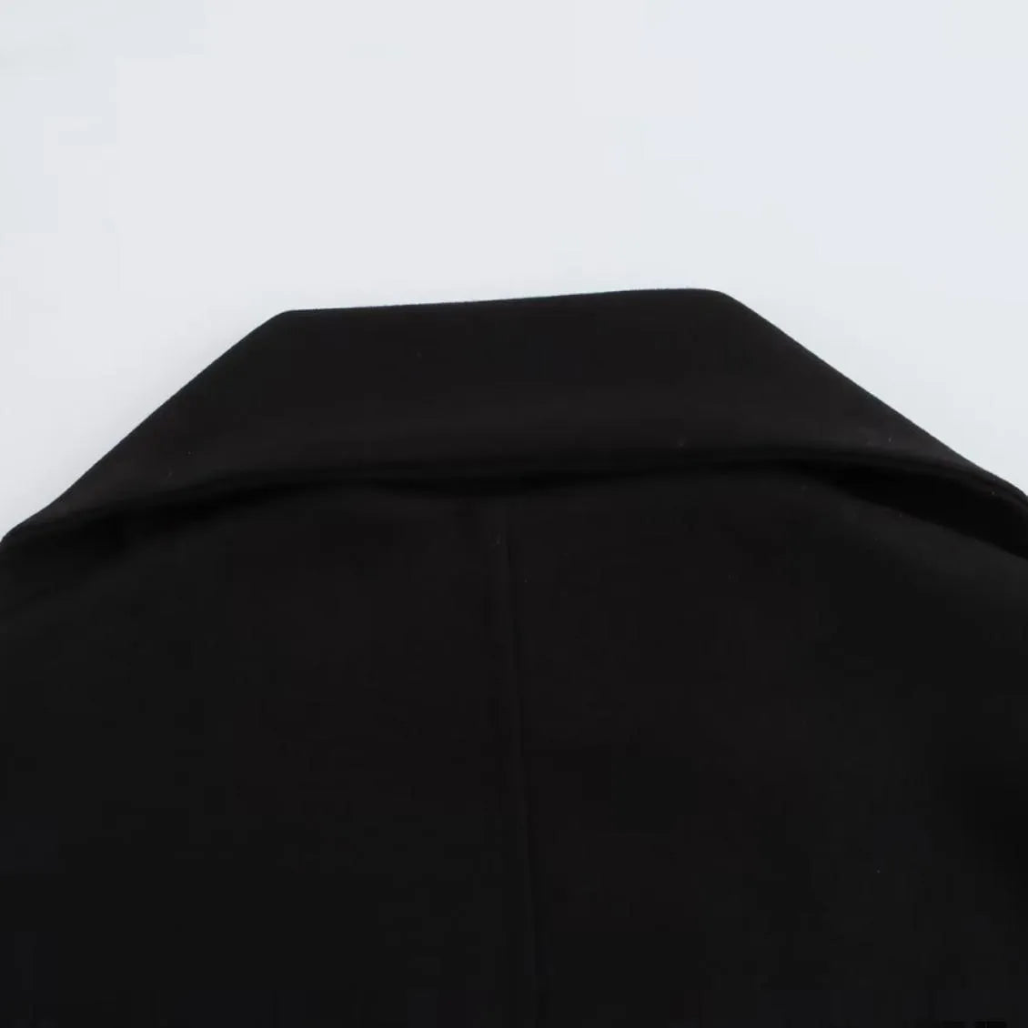 Women's long grey overcoat with a fluffy artificial fur collar, styled in a street fashion setting.
