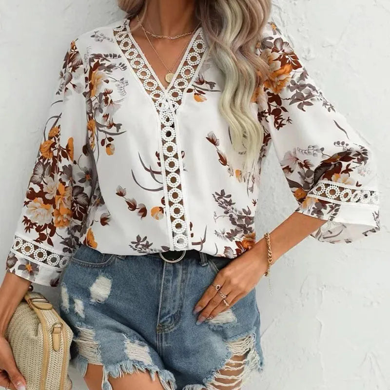 Loose V-neck pullover top with bell sleeves, lace trim, and printed pattern in white