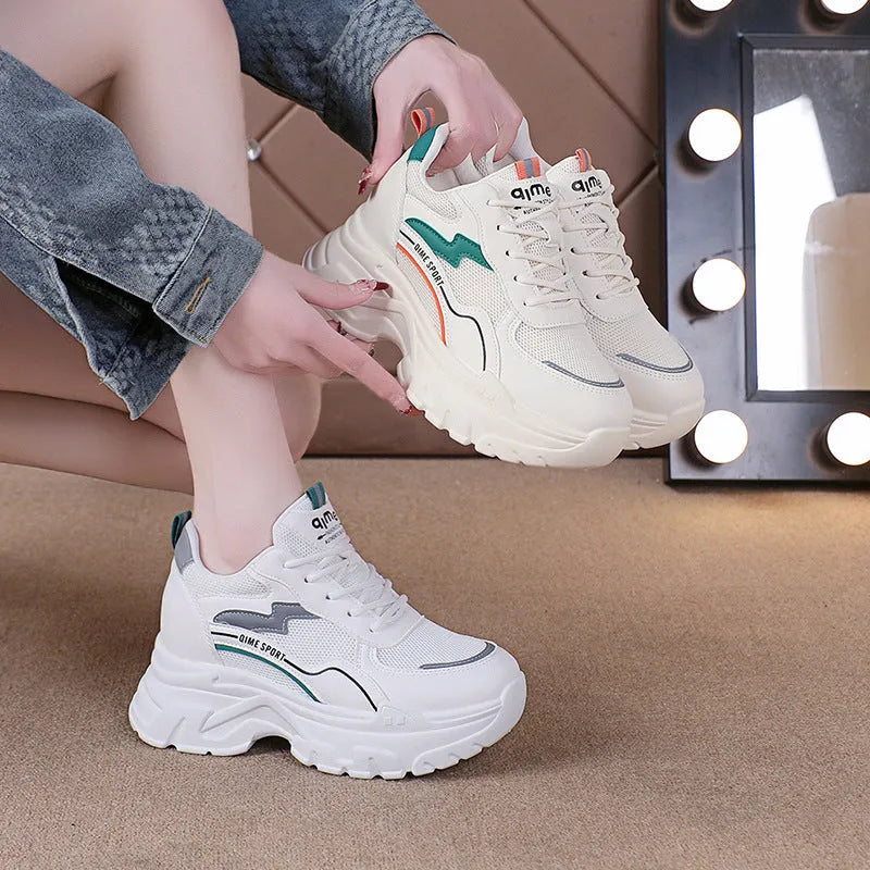 Women's white low-top sports trainers with cross shoulder straps and front laces, made of breathable mesh.