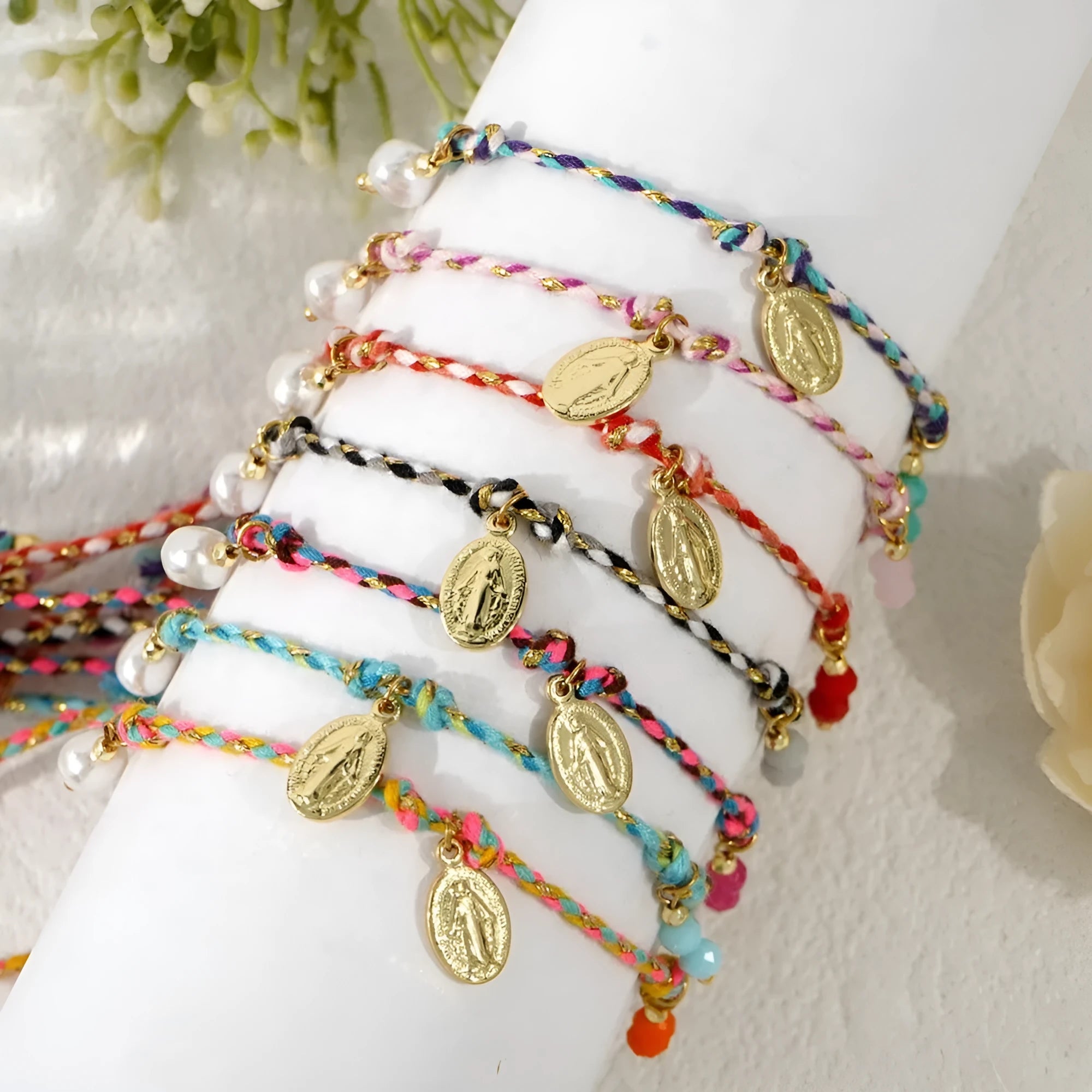 Close-up of a women's hand-woven ethnic bracelet made from colourful braided rope, showing the integrated carrying strap tag.