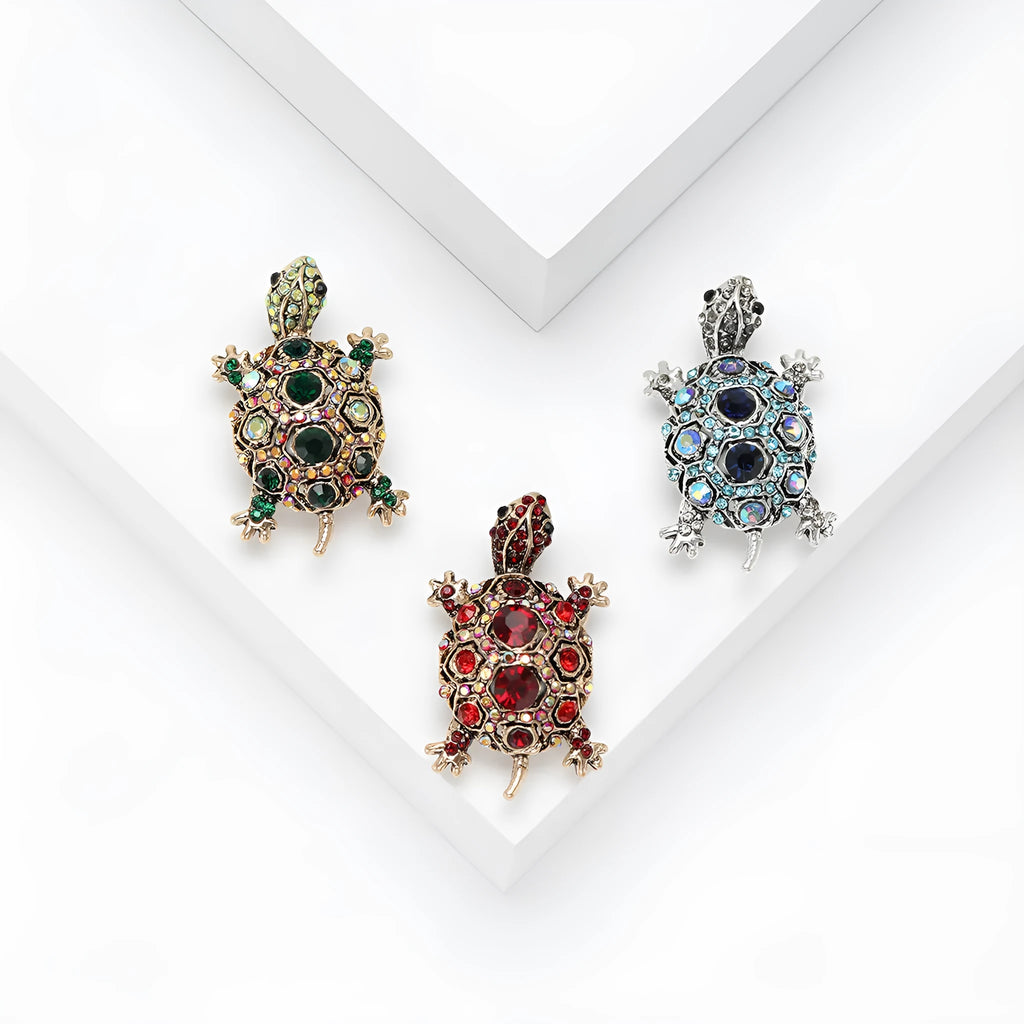 Close-up of a retro-style rhinestone turtle brooch in alloy, shown in blue, green and red colour options.