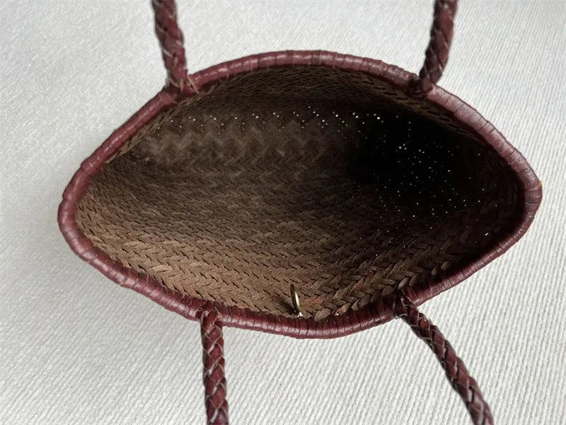Brown handmade woven leather tote bag with a three-dimensional front pocket.