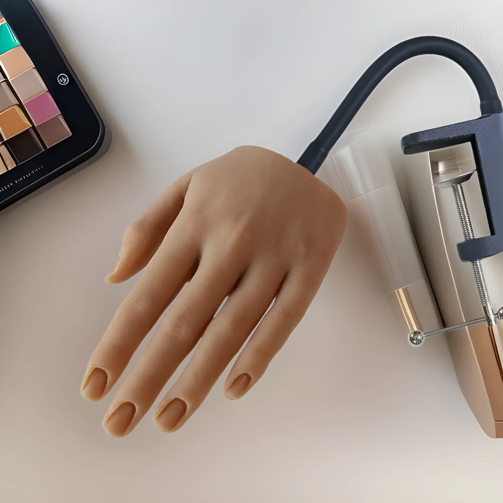 Silicone nail art practice hand model with movable fingers on a table.