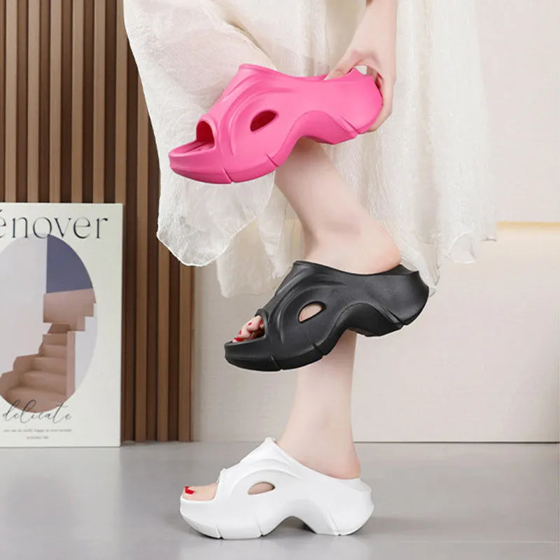 Women's white thick-soled EVA slippers on a sandy beach background.