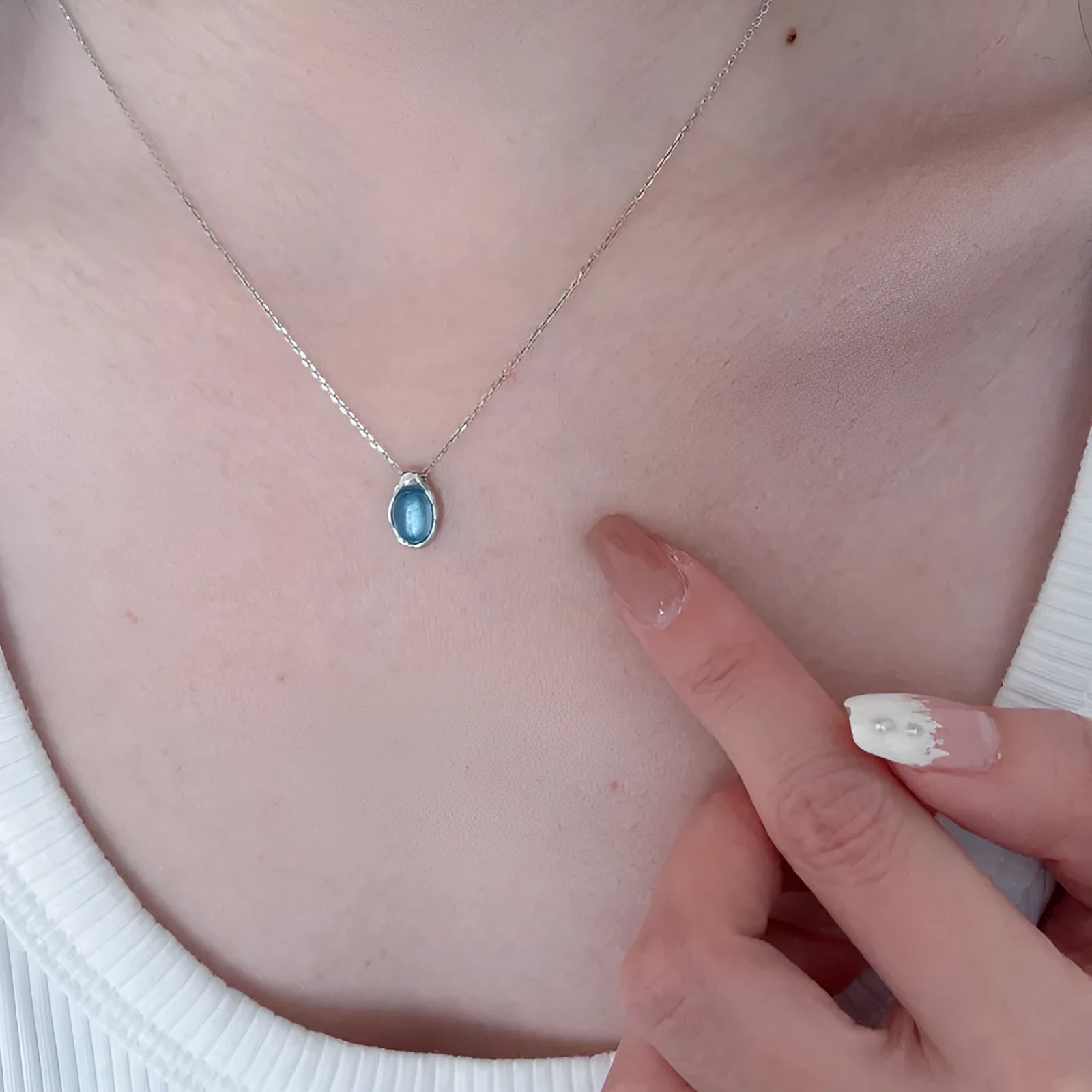 A women's navy blue geometric water drop pendant necklace with a platinum-colour finish on an adjustable cross chain.
