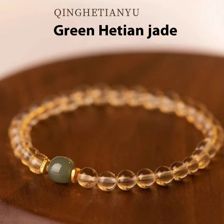 Close-up of a handmade adjustable bracelet made from natural rutilated quartz beads with golden rutile needle inclusions.