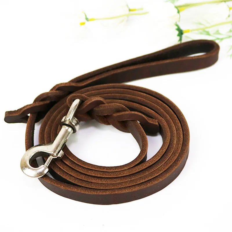 Thickened brown cowhide dog walking rope held in a hand, showing its length and simple strip design.