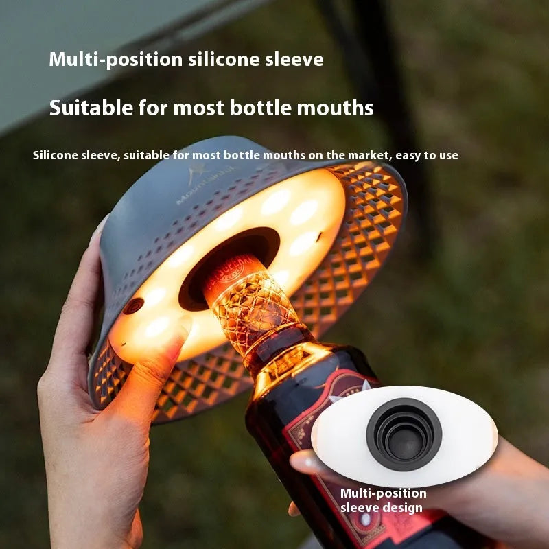 Beige rechargeable camping lantern with a wine bottle-shaped shade showing its USB-C port and gear switch.