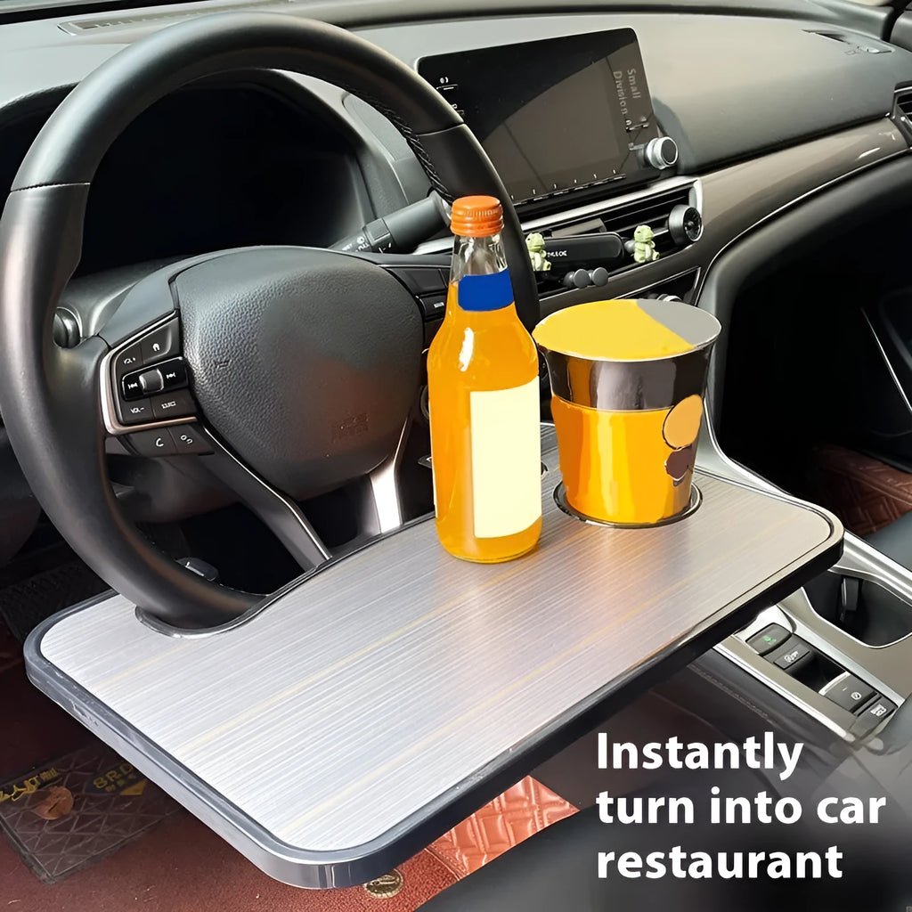 Black foldable car steering wheel laptop stand with a drink cup holder on a table.