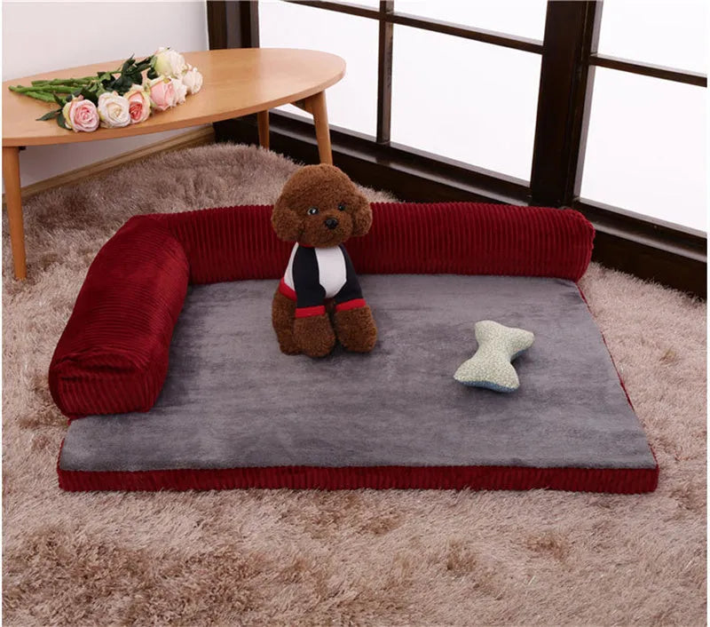 Grey corduroy pet sofa dog bed with bilateral bolsters and a non-slip cloth base on a wooden floor.