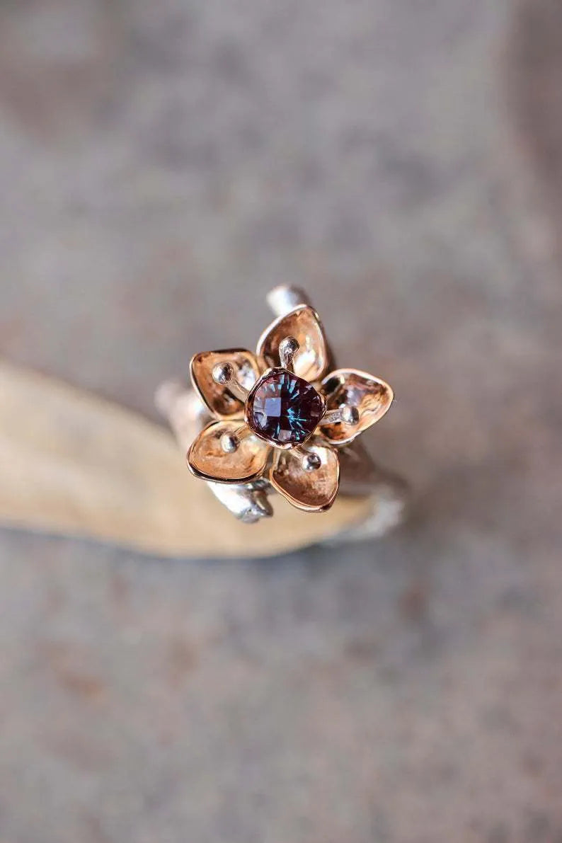 Silver two-tone women's alloy ring with a geometric floral design on a plain background.