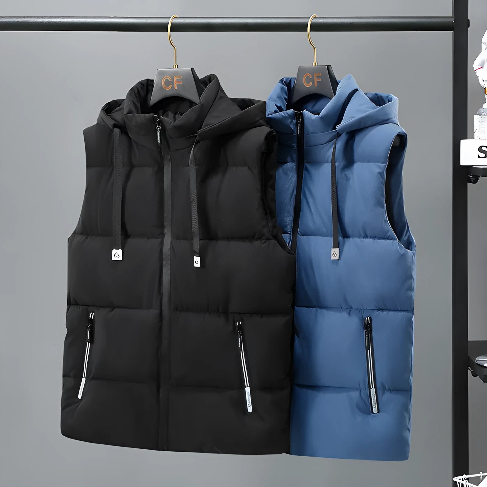 Man wearing a solid blue thickened vest with a removable hood and slant pockets.