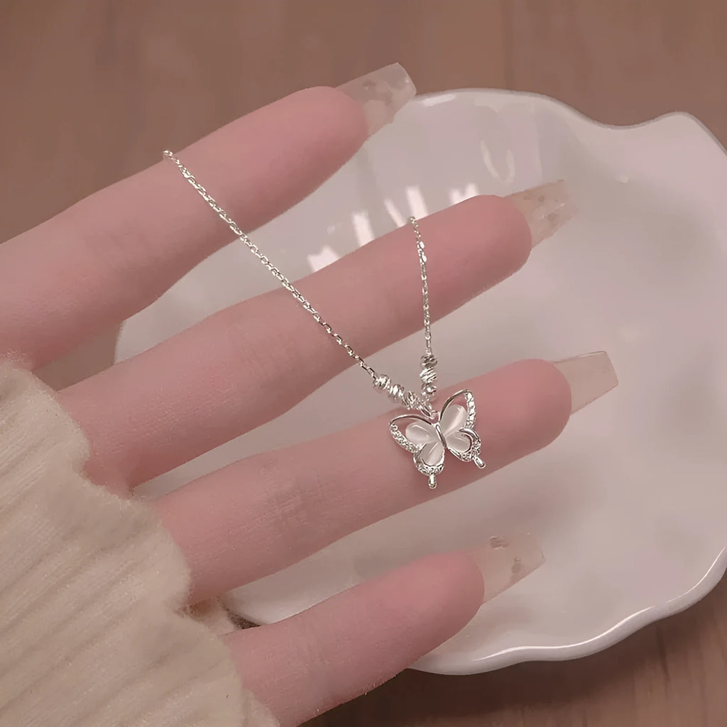 Women's silver butterfly opal pendant necklace on a cross chain, showing adjustable length.