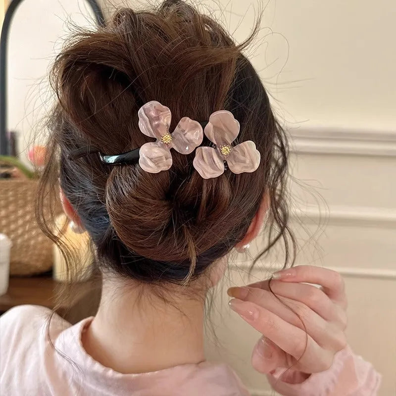 Close-up of a retro-style floral bobby pin with coloured acrylic petals.