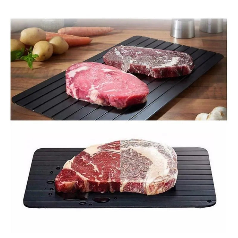 Black rectangular aluminium fast defrost tray for thawing frozen food on a kitchen counter.