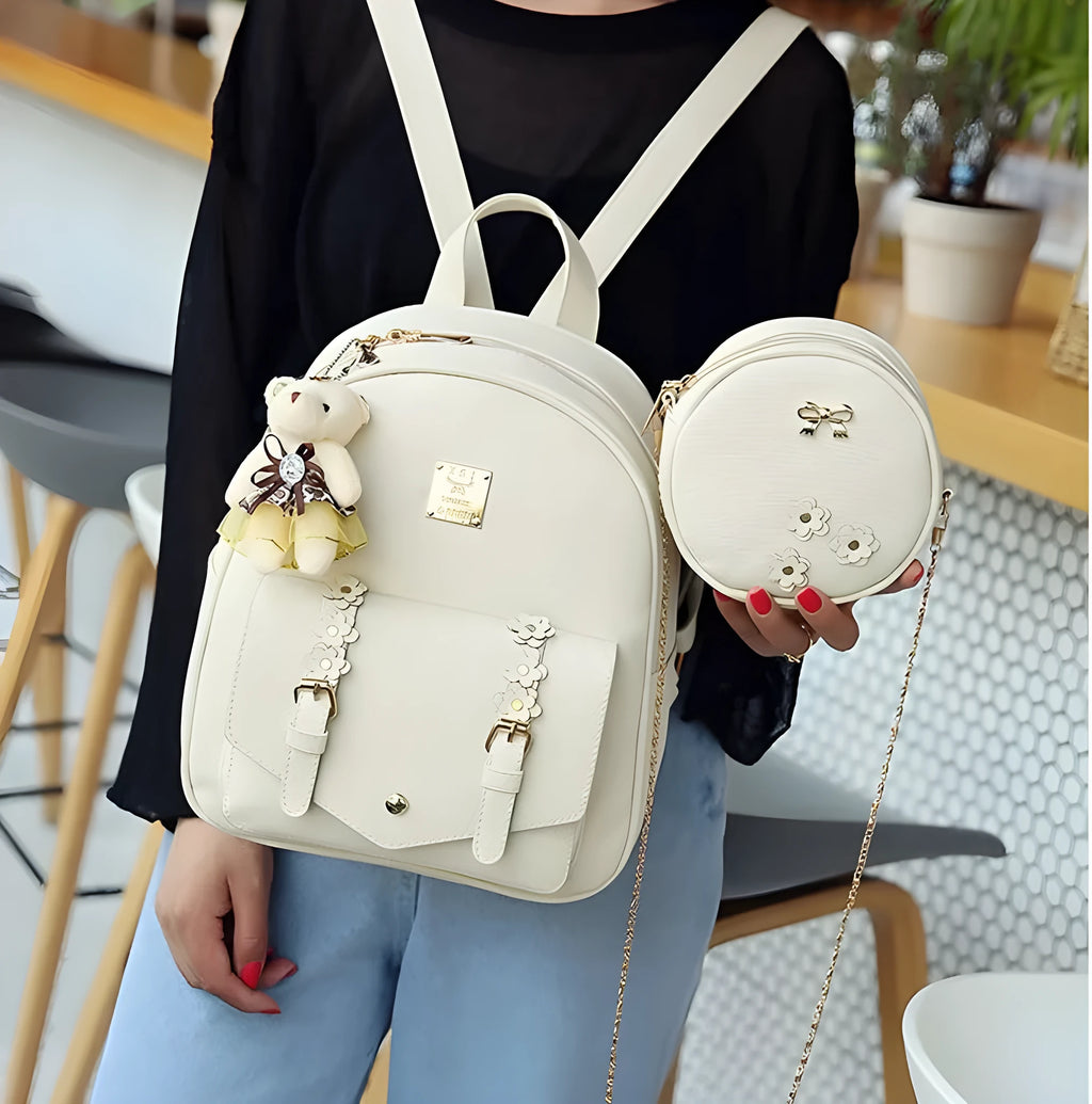 Women's three-piece PU leather bag set showing backpack, shoulder bag, and card holder with floral detailing