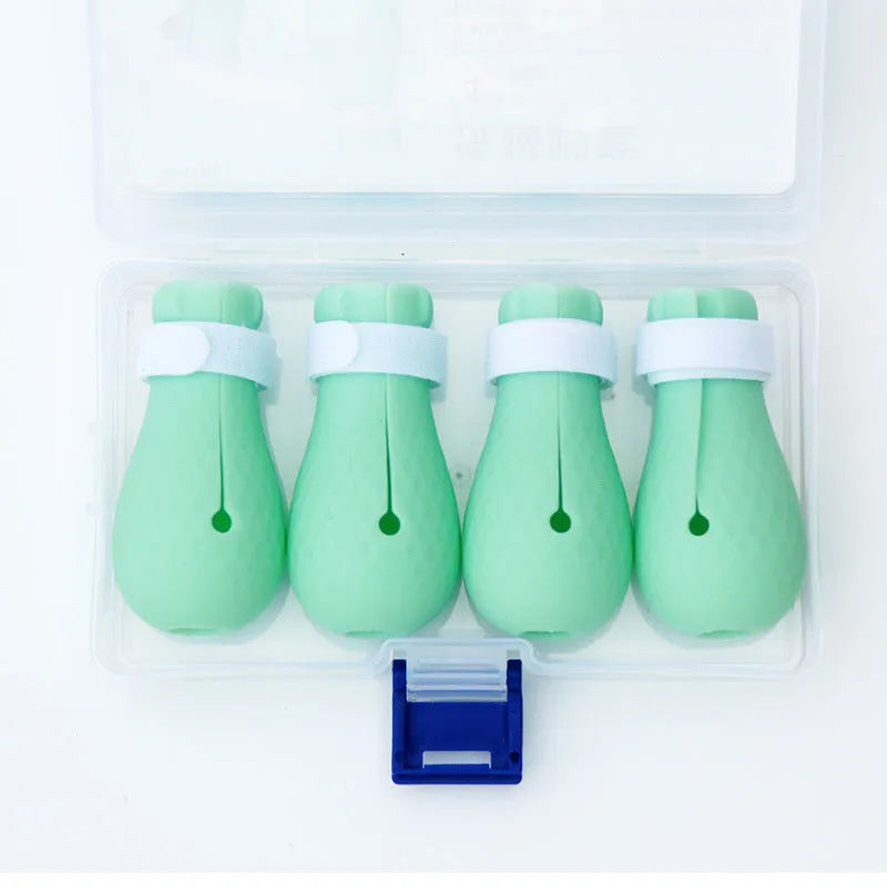 Four green silicone cat anti-scratch foot covers for pet handling protection