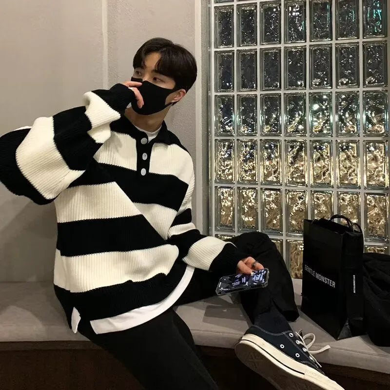Man modelling a loose-fit black and grey striped polyester sweater coat, a long-sleeve pullover.